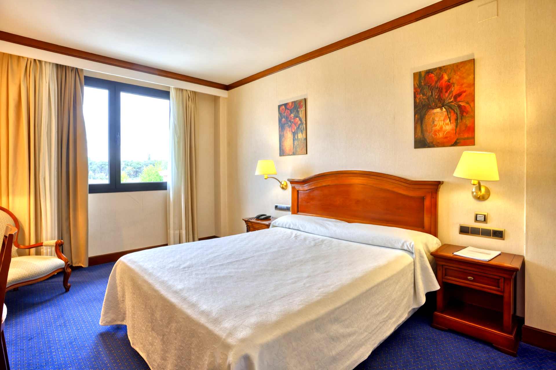 Habitación con ventana y luz natural cálida Cama doble con vistas en la ventana del Hotel Alda Villa de Almazán