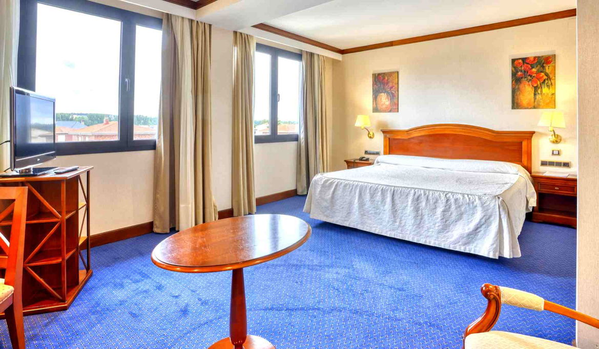 Cama doble con vistas en la ventana del Hotel Alda Villa de Almazán