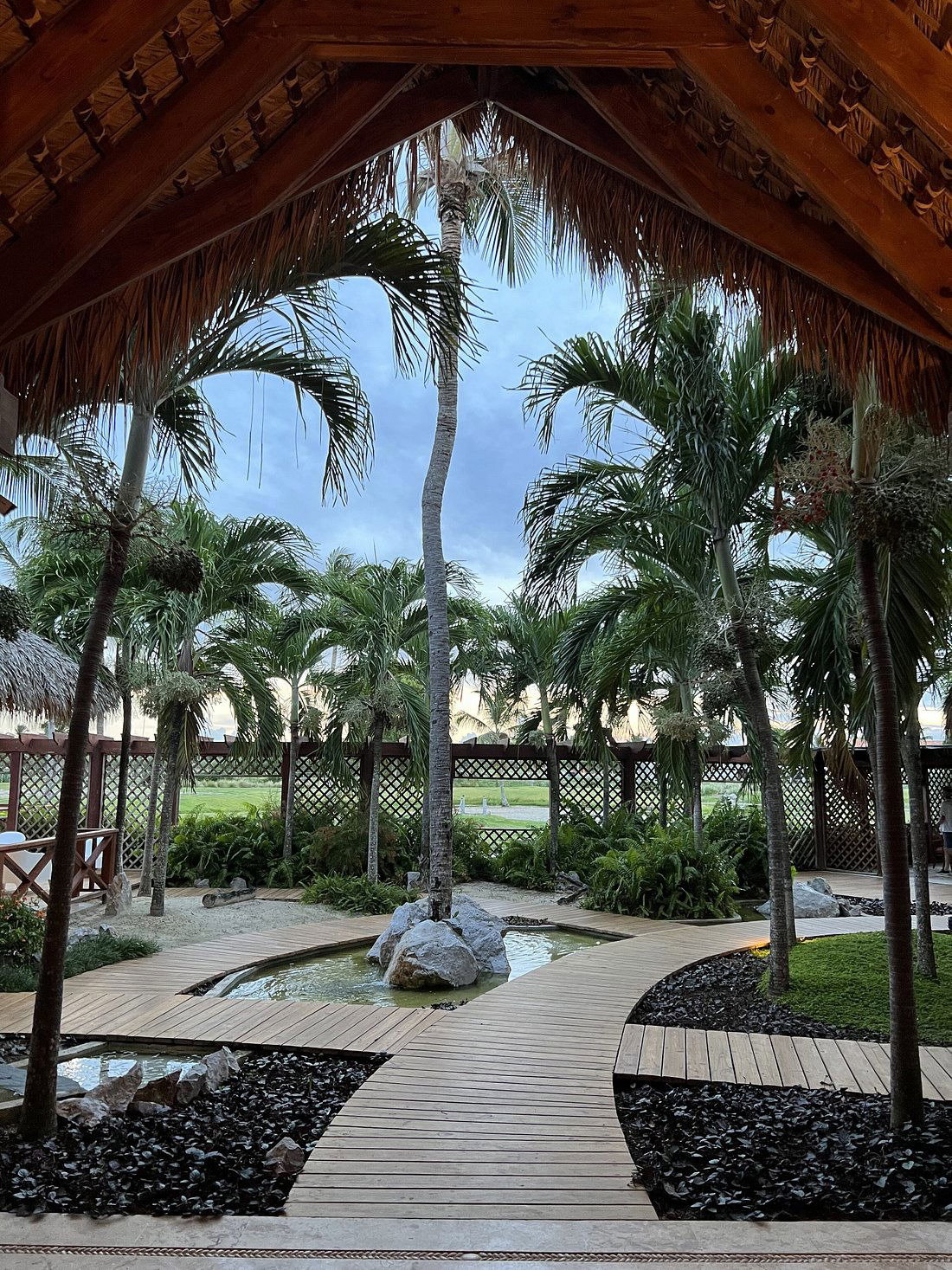 Vista aérea de una piscina sinuosa rodeada de jardines y edificios de apartamentos con tejados de teja