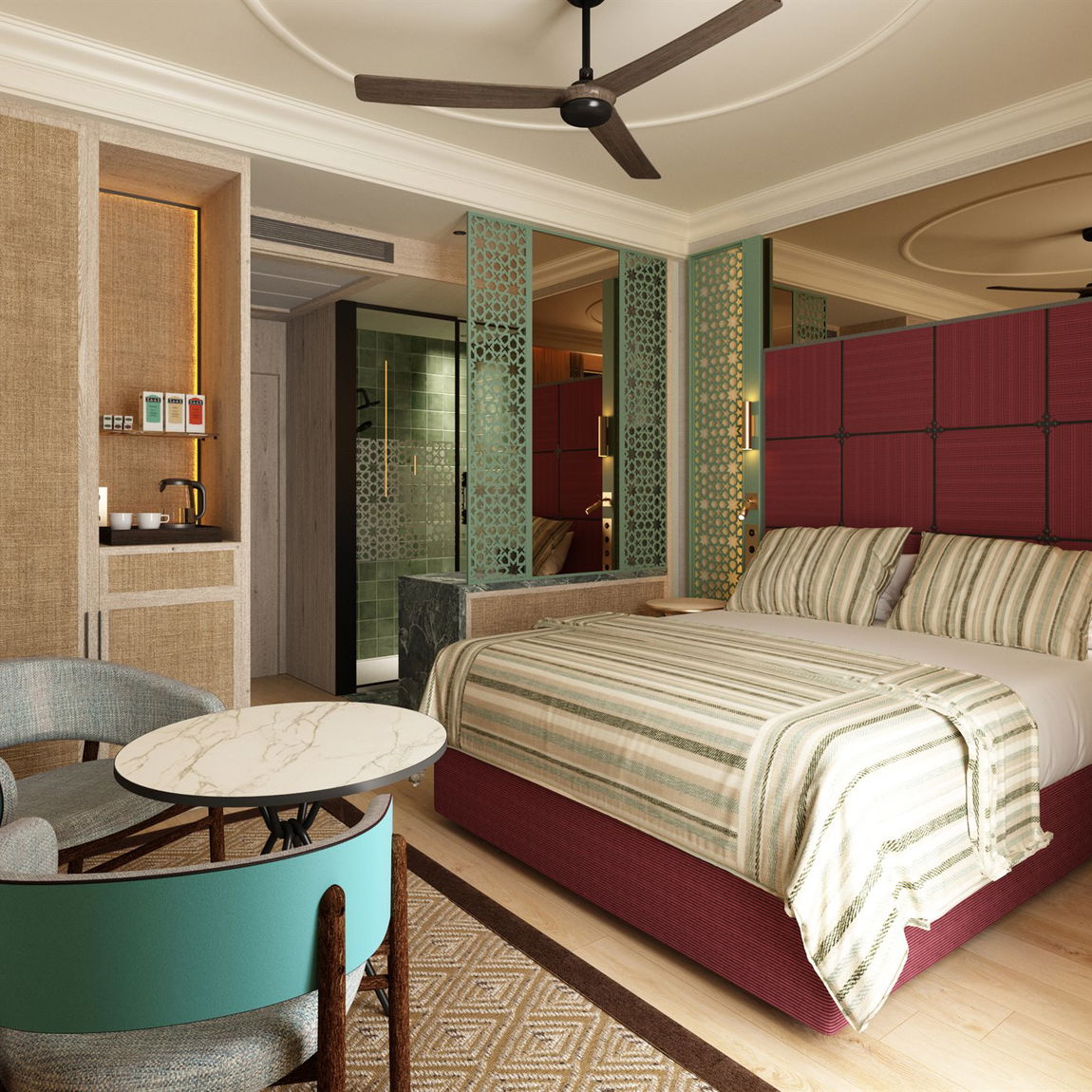 Habitación con cama de matrimonio, cabecero granate acolchado, colcha de rayas, ventilador de techo, butacas verde azulado con mesa redonda de mármol y celosías verdes caladas hacia el baño