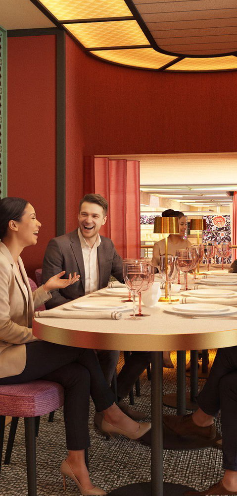 Sala privada con mesa redonda preparada para un grupo, sillas en tonos rosa y granate
