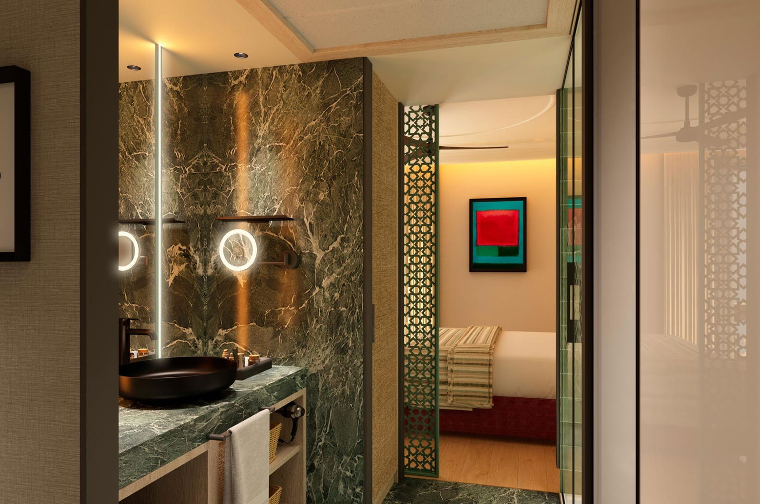 Baño con lavabo negro sobre encimera de mármol verde, espejos redondos iluminados y paso al dormitorio al fondo