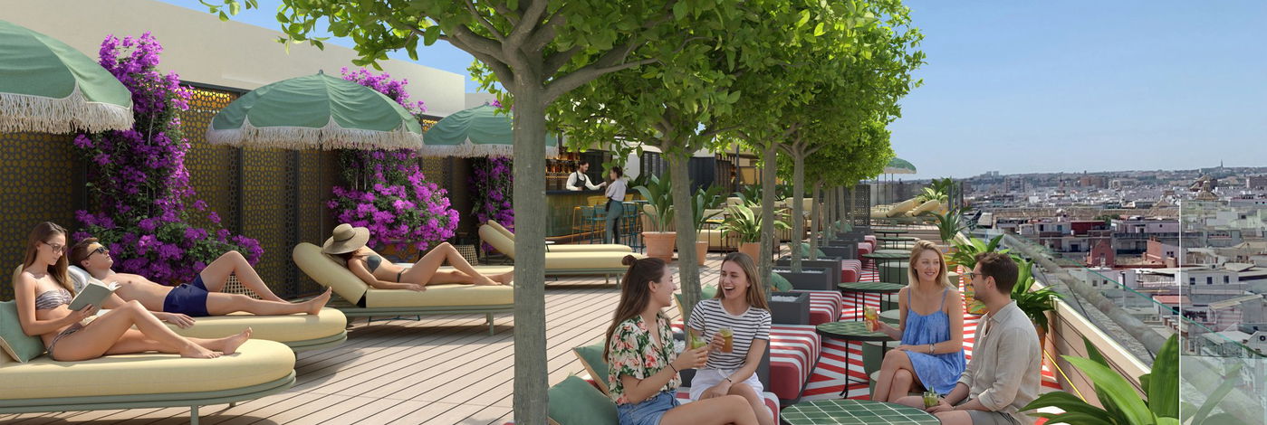 Huéspedes descansando en las tumbonas de la terraza de la azotea con vistas a Sevilla