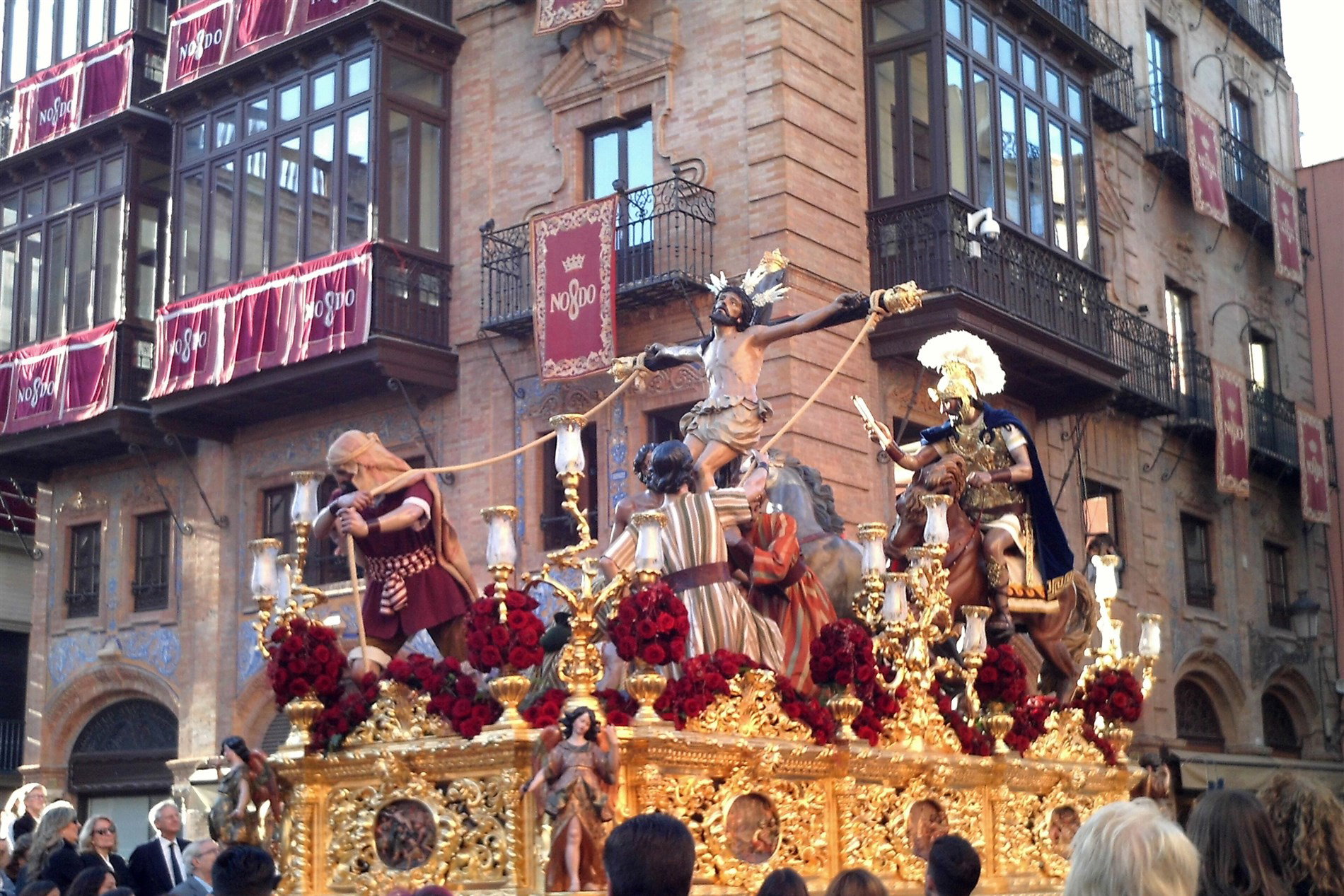 Paso del Cristo de la Exaltación en procesión por una calle del centro de Sevilla